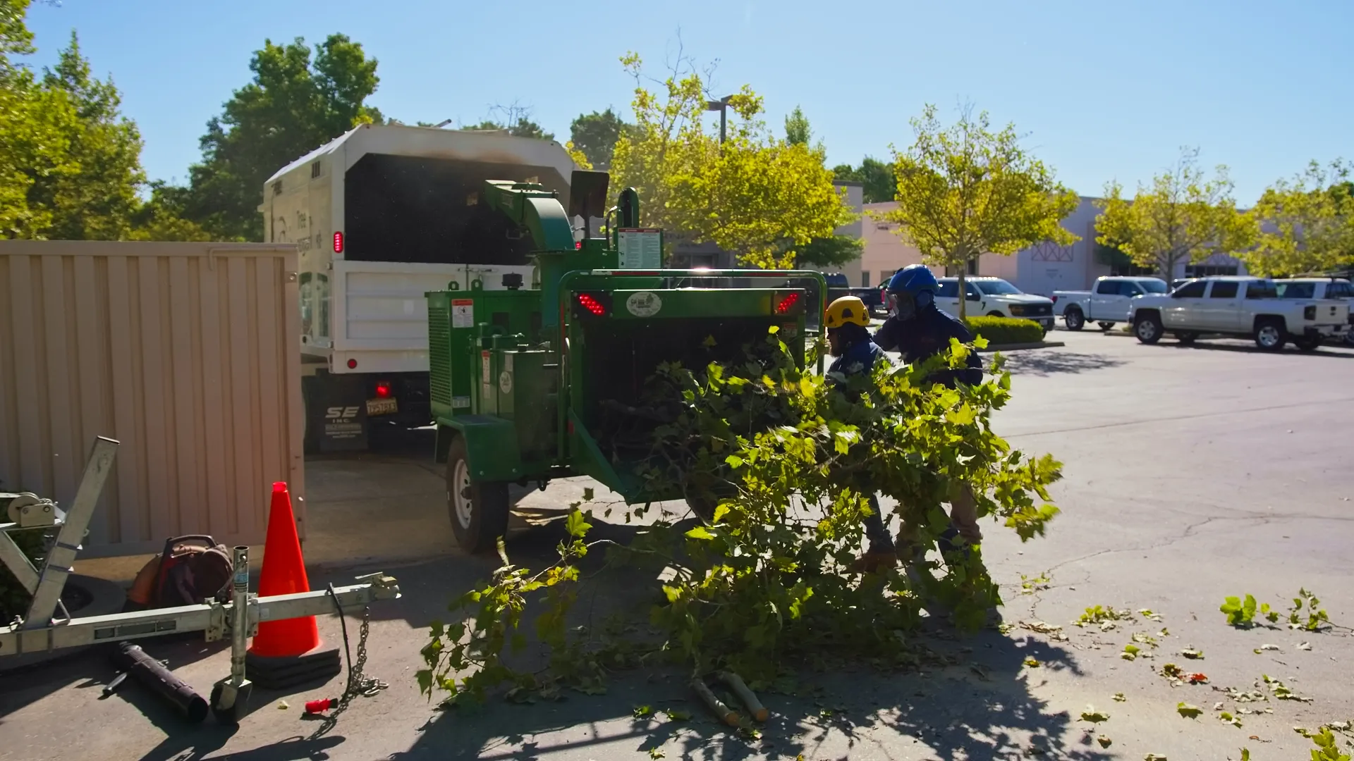 JG Landscape Management crew feeding branches into a wood chipper for haul-away