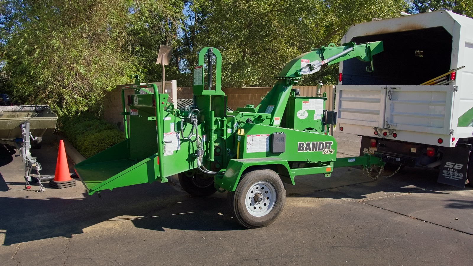 JG Landscape Management wood chipper and equipment trailer on a job site